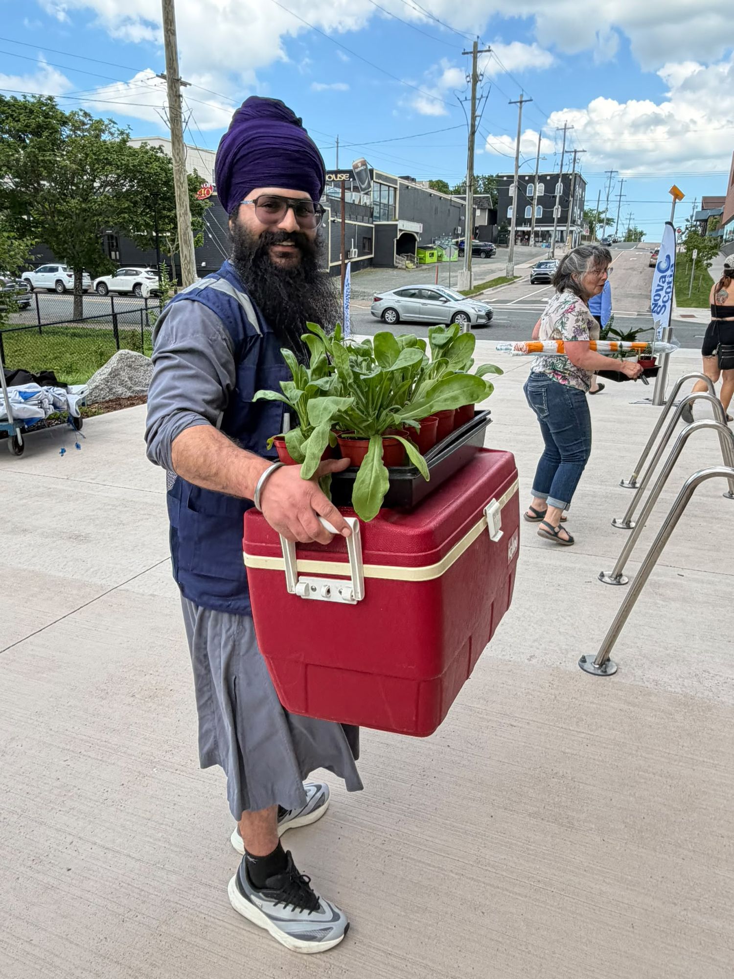 BSA volunteer carrying seedlings for the community garden